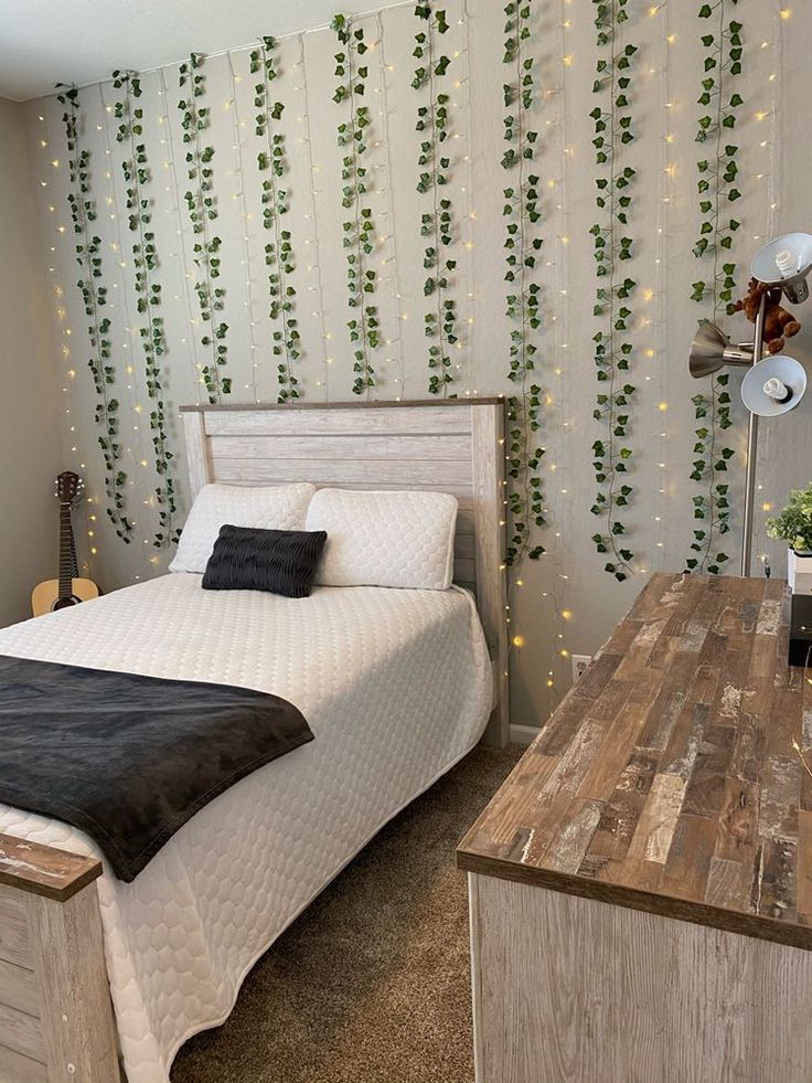 a bed sitting next to a wooden table in a room with lights on the wall