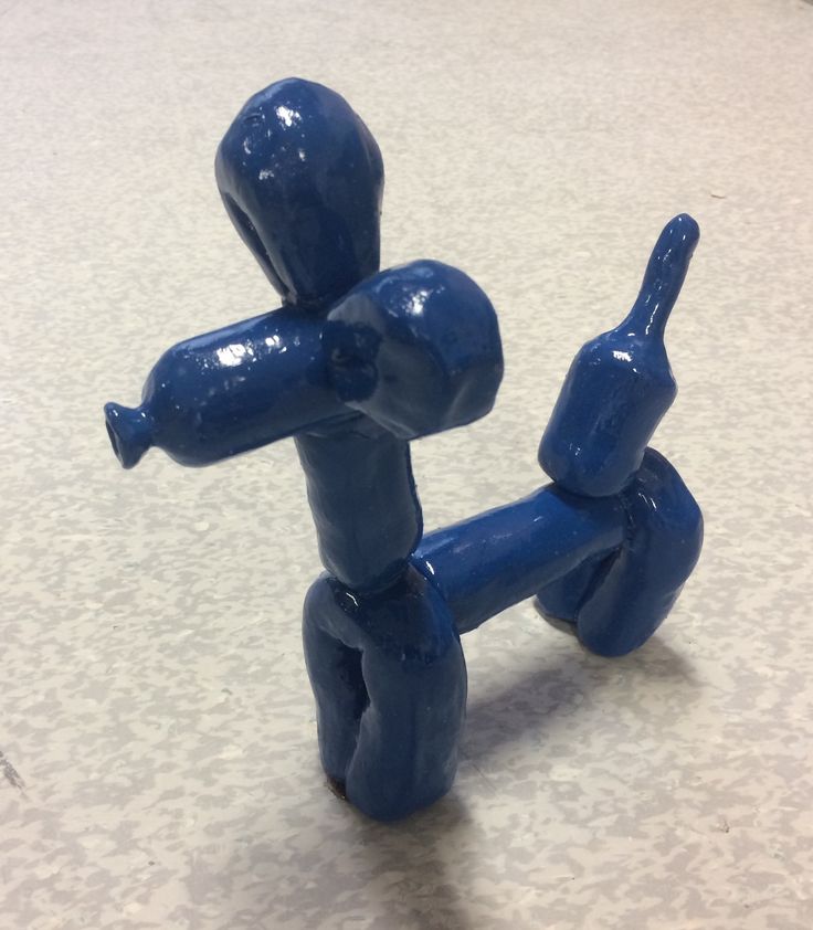 a blue plastic figurine holding a thumbs up