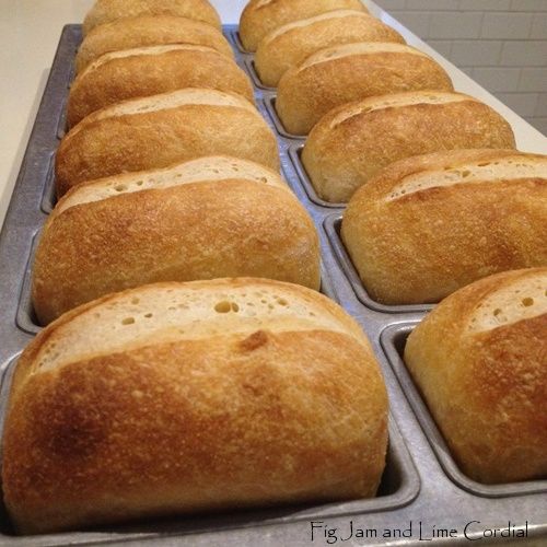 several loaves of bread sitting in a muffin tin on a counter top, ready to go into the oven