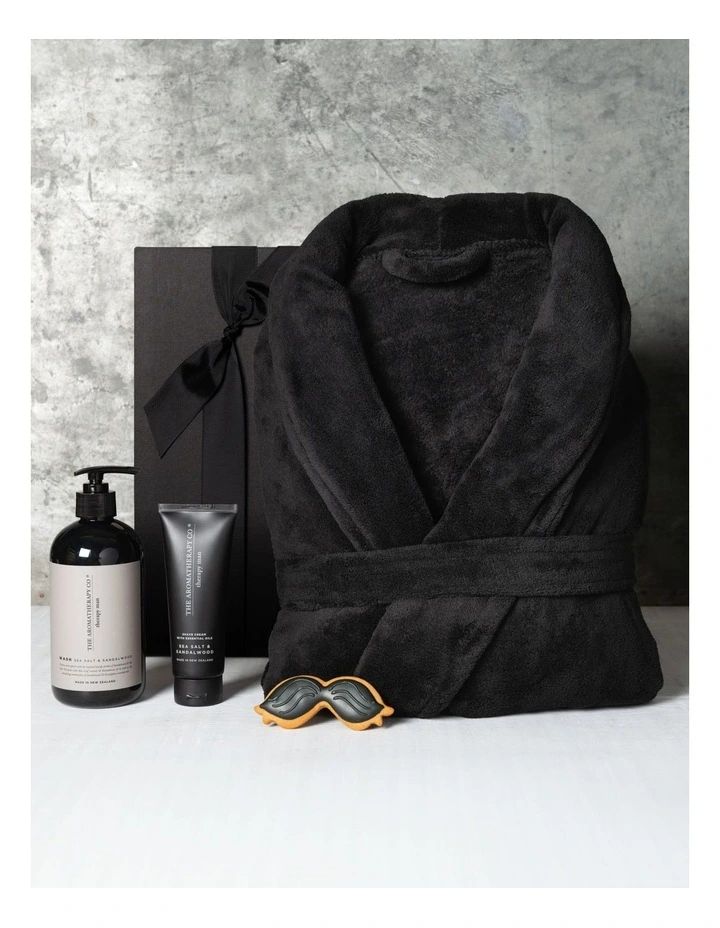 a bathrobe, hand towel, and body lotion are sitting on a table