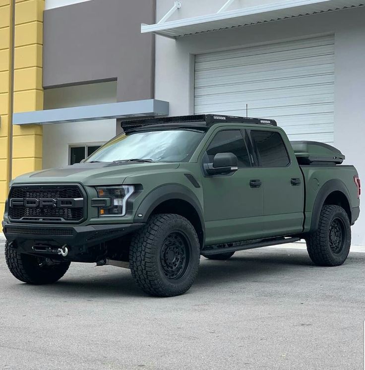 a green truck parked in front of a building