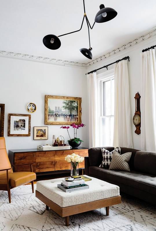 a living room filled with furniture and pictures on the wall above it's windows