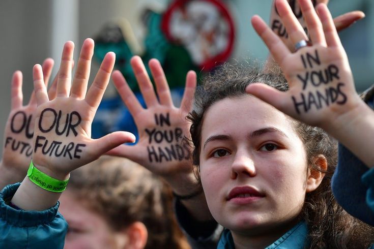 a group of people with their hands in the air holding up some writing on their palms