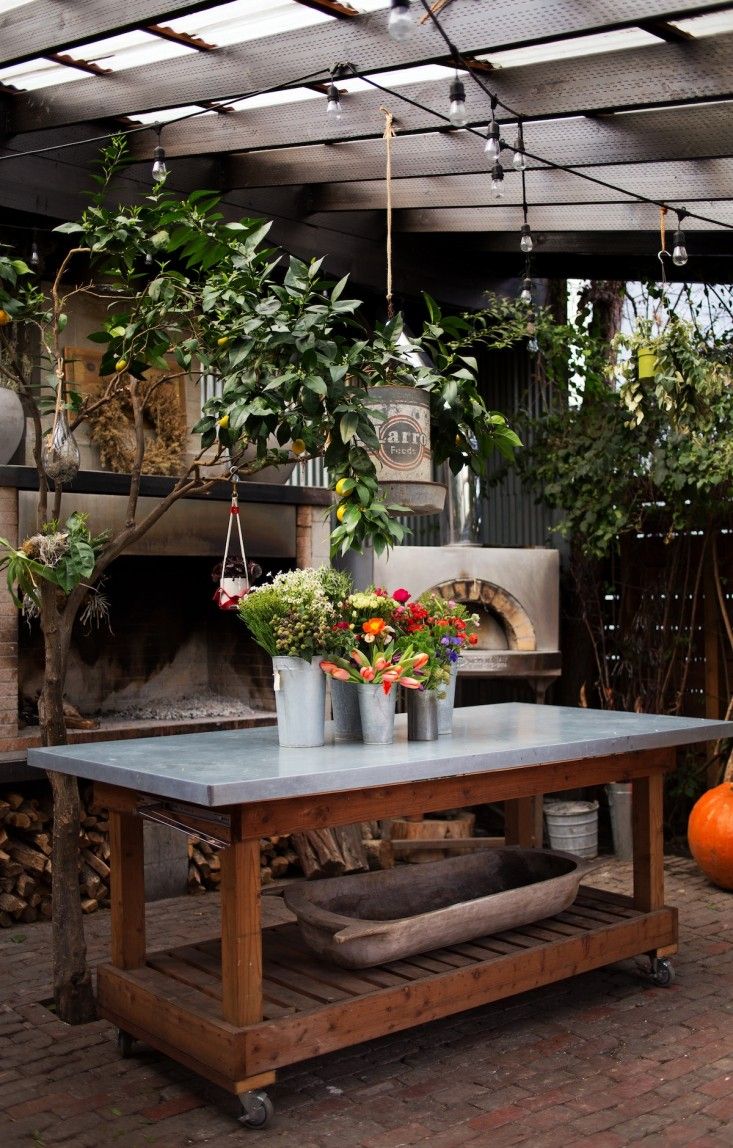 a table with potted plants on it in front of a fire place and an oven