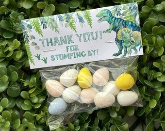 there is a bag of white and yellow candies in front of some green bushes