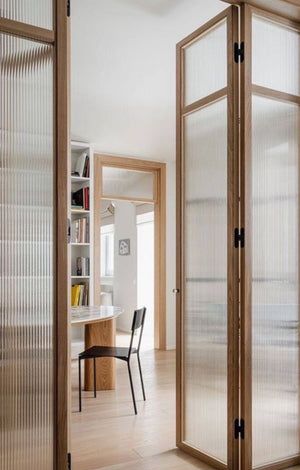 an open door leading to a dining room with a table and chairs in the background