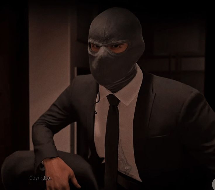 a man in a suit and tie wearing a mask