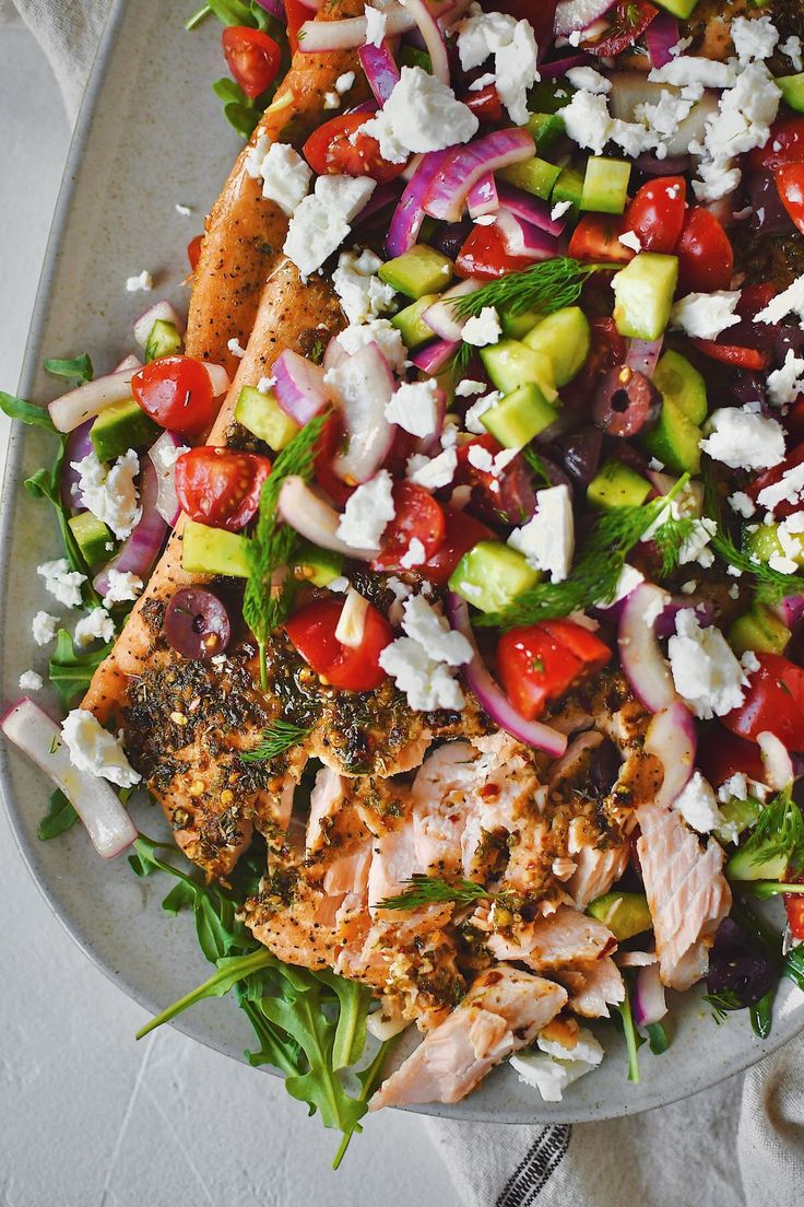 a salad with chicken, tomatoes, cucumbers, onions and feta cheese