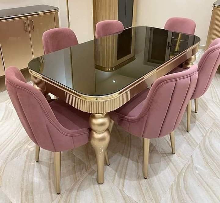 a dining room table with pink chairs around it