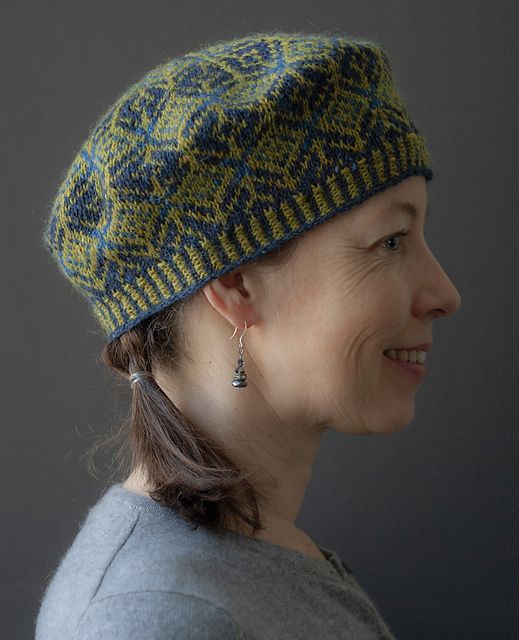 a woman wearing a green and blue hat