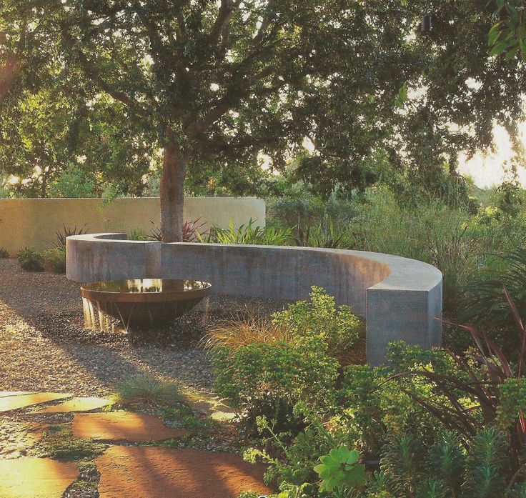 a concrete bench sitting next to a tree