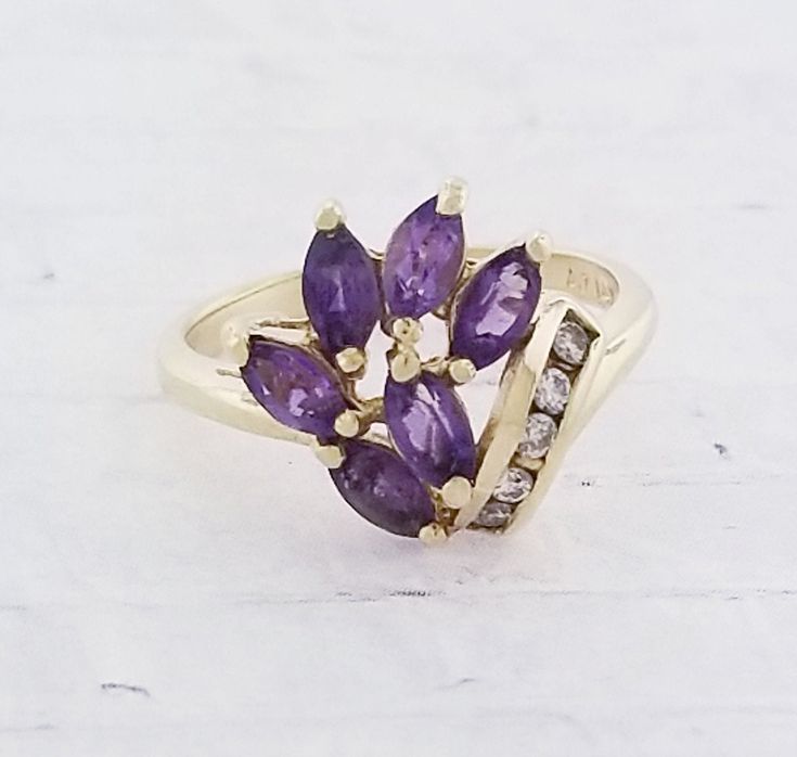 Vintage Amethyst & Diamond ring. Details: Size: US 5 ( can be sized ) Weight: 3.2 grams Primary stone: Amethyst Shape: Marquise ( 6 stones in total ) Secondary Stone: Diamond Shape: Round Metal: 14k Yellow Gold Condition: Previously worn/great condition Inside of band is stamped and tested for '14k' gold. All pieces are polished and refinished in our shop. SIZING: Currently this ring is a size 5 but could be sized up or down for an additional small fee if desired by adding custom ring sizing Purple Cluster Rings For Formal Occasions, Formal Purple Cluster Rings, Lavender Multi-stone Amethyst Ring In Fine Jewelry, Lavender Multi-stone Amethyst Ring Fine Jewelry, Cluster Amethyst Gemstone Rings, Amethyst Cluster Rings With Gemstone, Lavender Multi-stone Amethyst Ring, Purple Cluster Jewelry For Formal Occasions, Amethyst Cluster Gemstone Rings