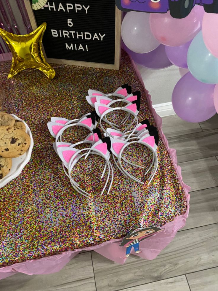 a table topped with cookies and glasses on top of a table covered in confetti