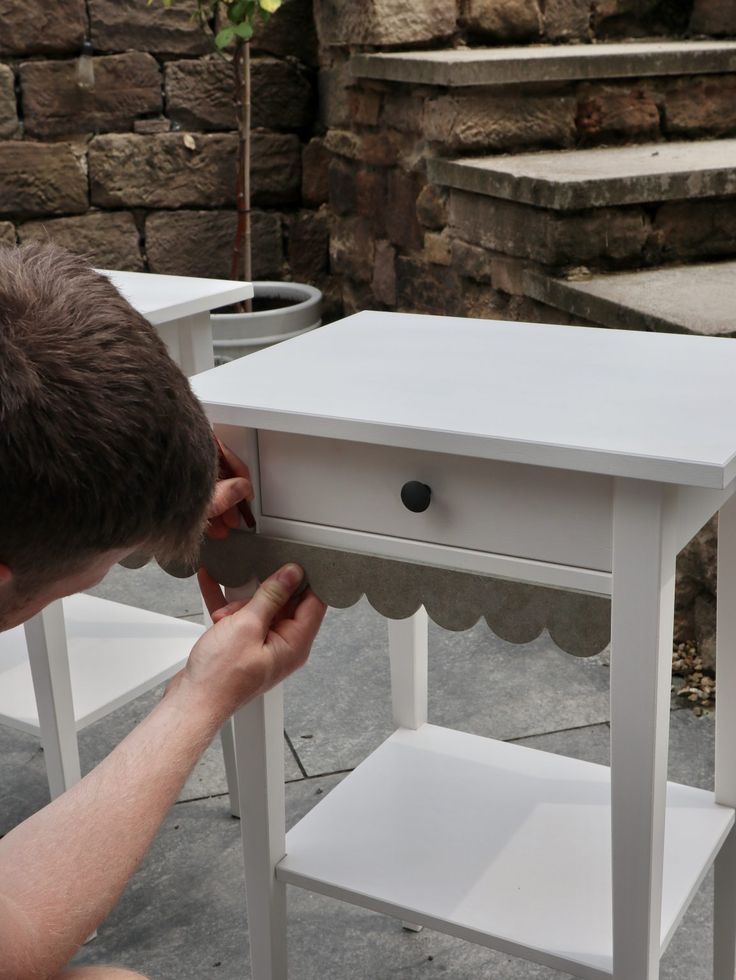 a man is working on a small white table