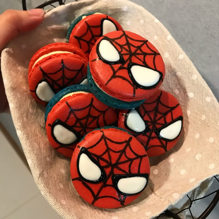 spiderman cookies on a plate with white icing