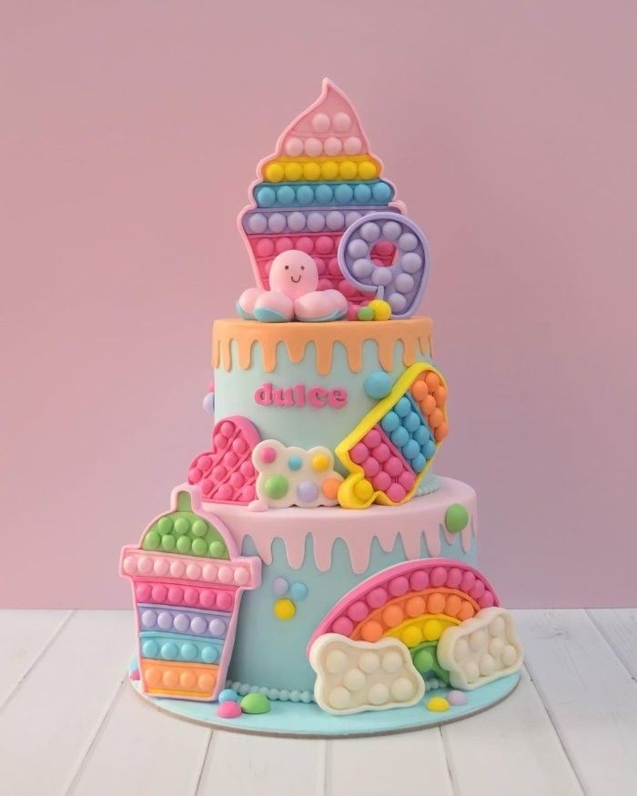 a multi layer cake decorated with fondant and candy