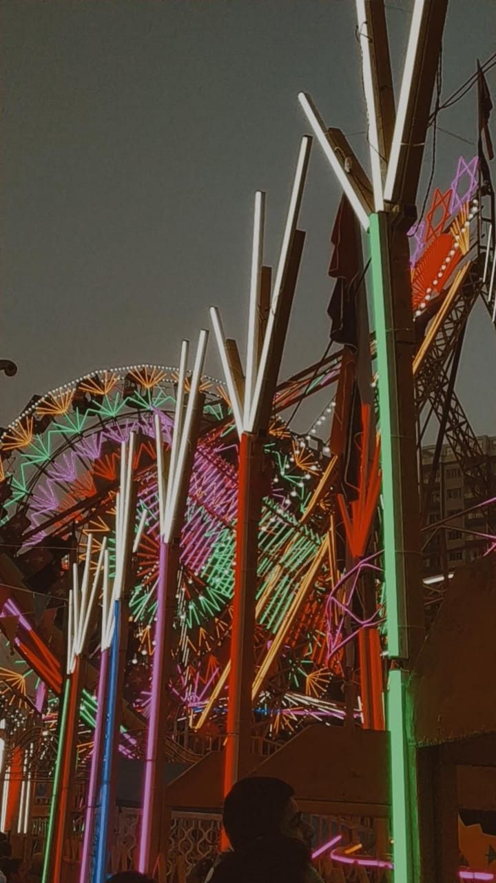 an amusement park with colorful lights and rides