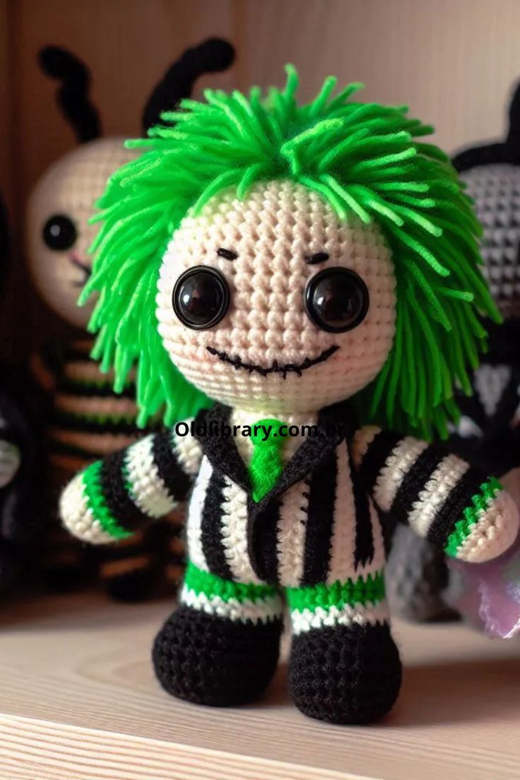 a crocheted doll with green hair sitting on a shelf next to other stuffed animals