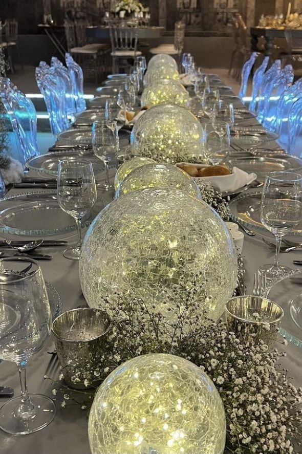 the table is set with clear glass vases