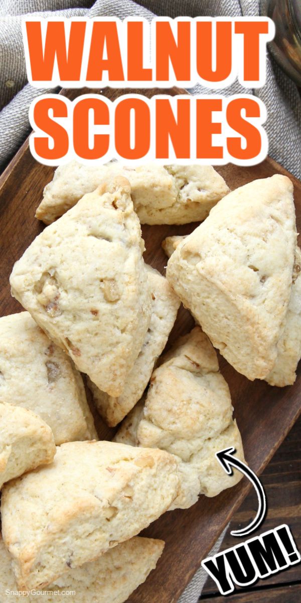 a wooden plate topped with scones on top of a table