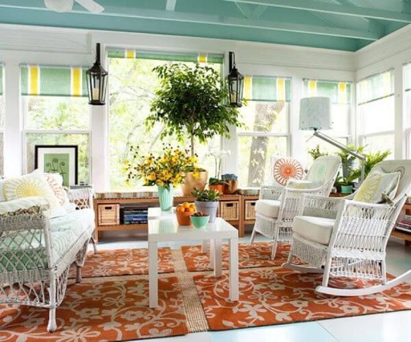 a living room filled with white rocking chairs and lots of plants on the windowsill