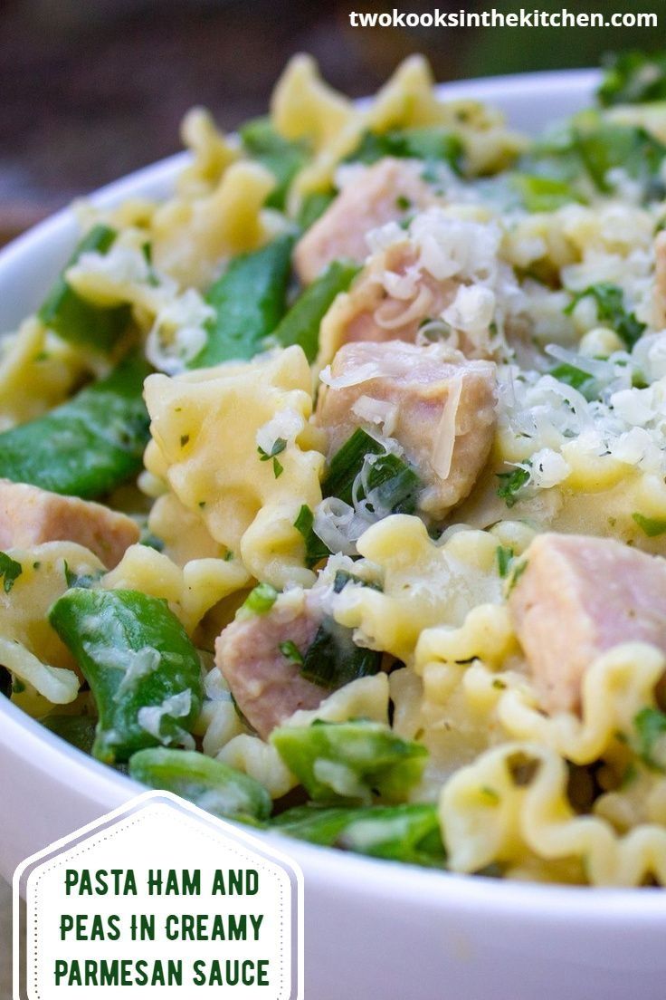 a white bowl filled with pasta, meat and veggies on top of a table