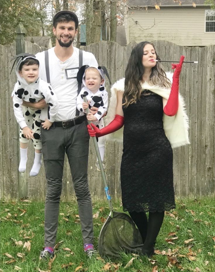 a man, woman and two children are dressed up in costumes while standing on the grass