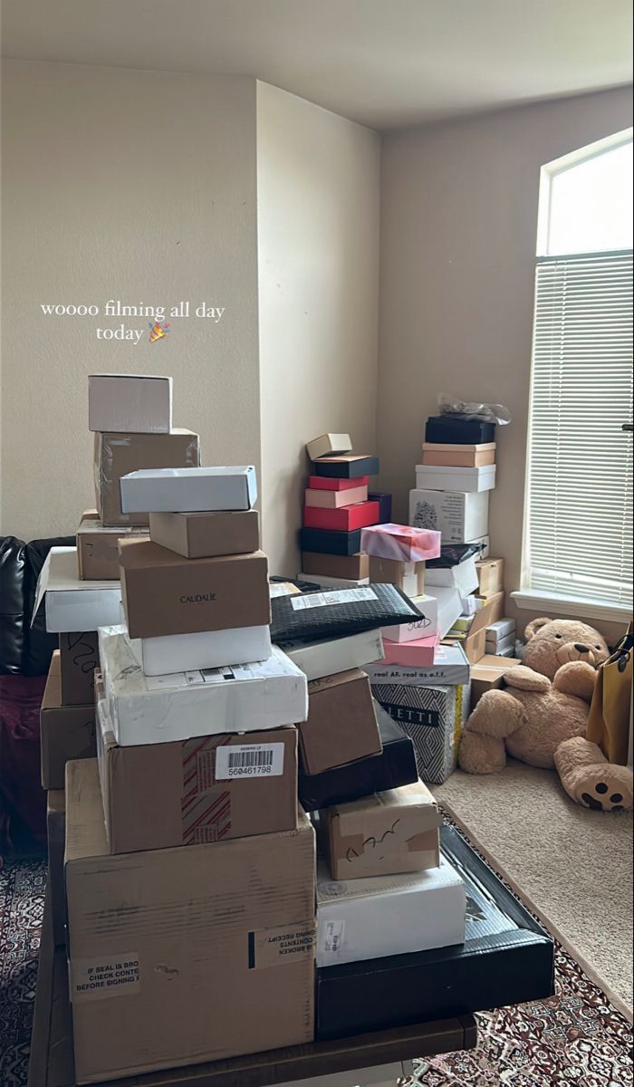 there are many boxes stacked on top of each other in the living room with teddy bears