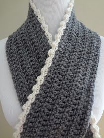 a gray and white crocheted scarf on a mannequin