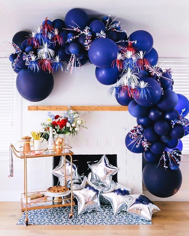 balloons and streamers are on the wall near a fireplace