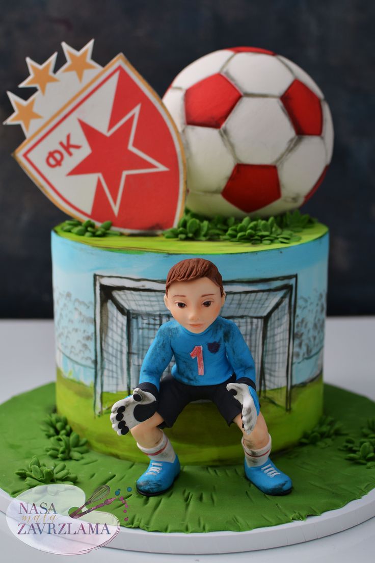 a cake with a soccer player on it and two balls in the background for decoration