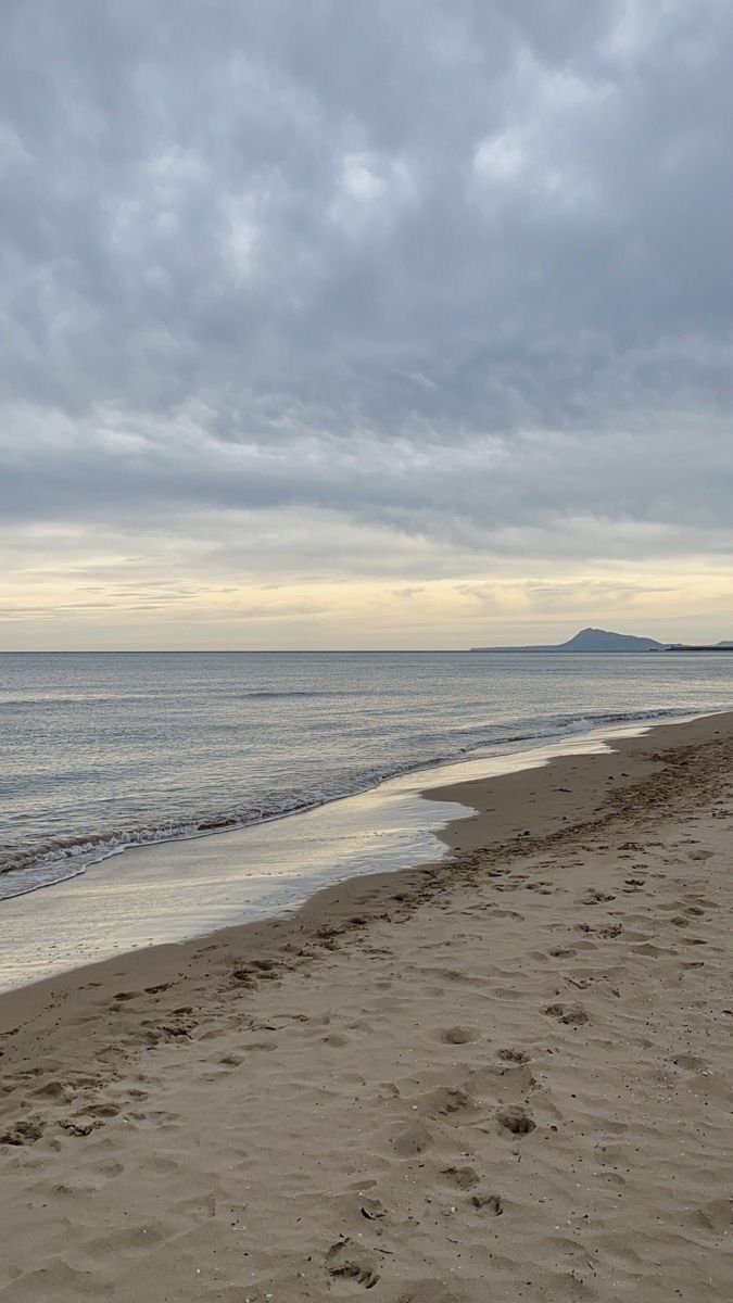 an empty beach with footprints in the sand