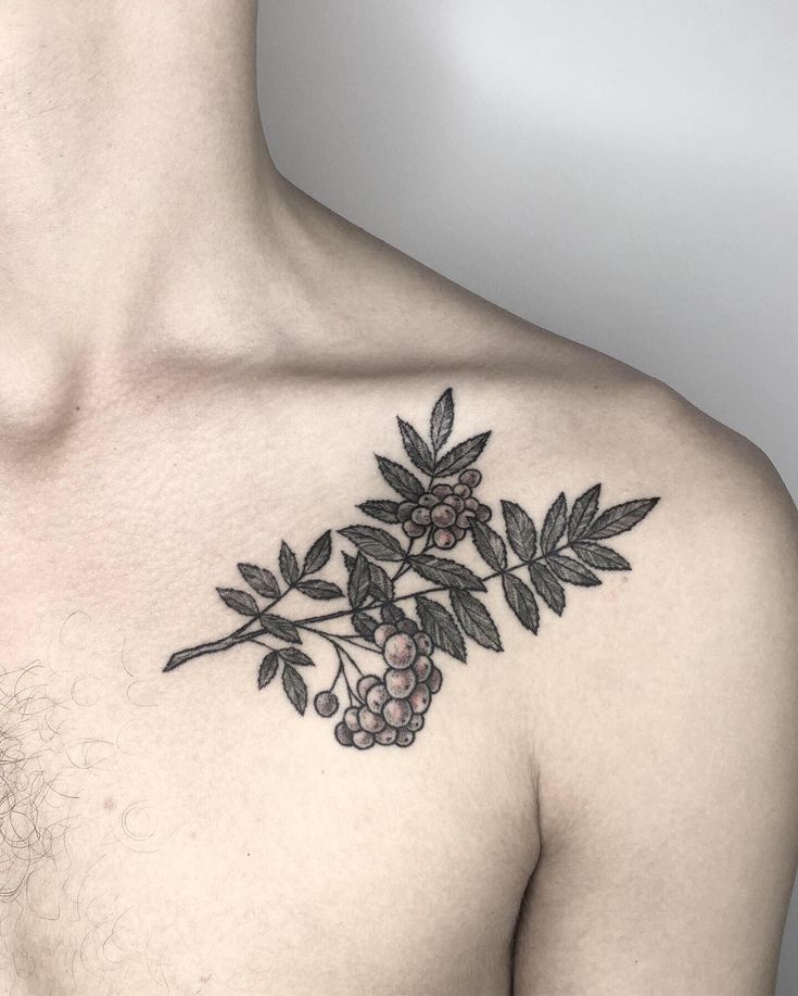 a man's chest is covered with black and white flowers, leaves and berries