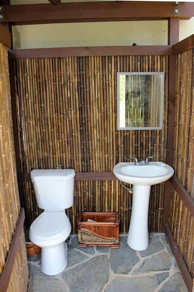 a bathroom with a sink, toilet and bamboo wallpaper on the walls in it