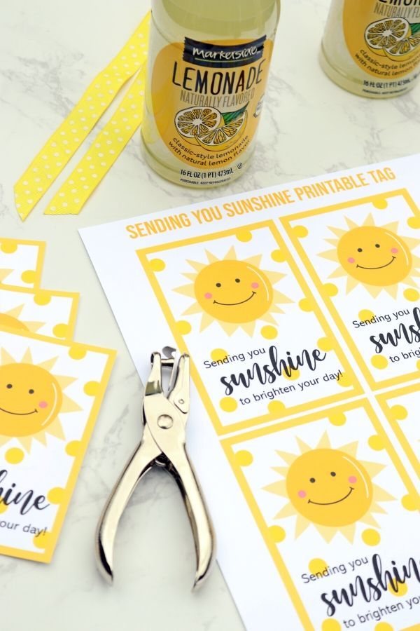 a bottle of lemonade sitting next to some scissors and tags on a table with other items