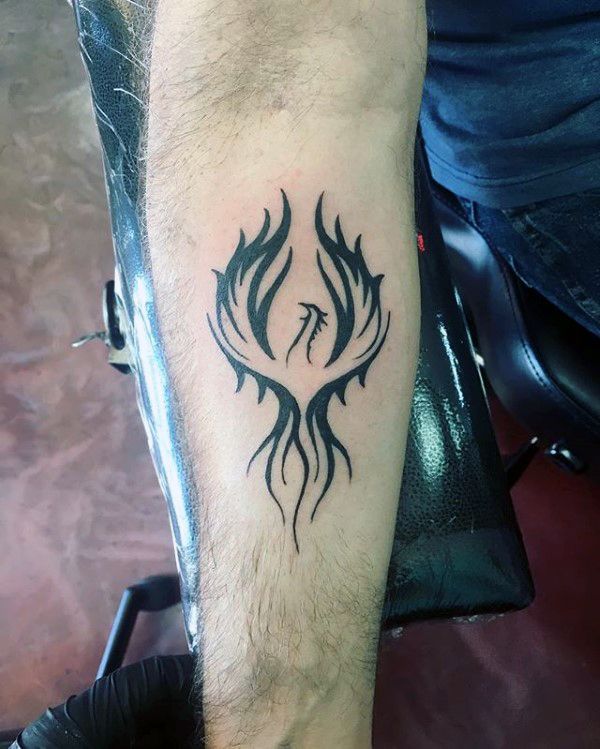 a man's arm with a tattoo on it and flames in the shape of a bird