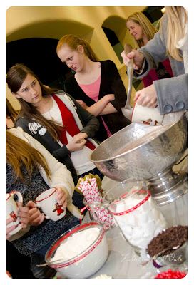 a group of women standing around a table filled with food