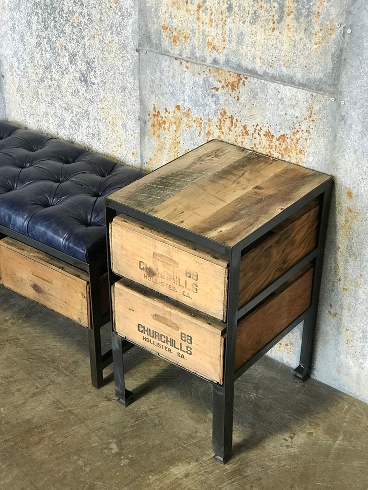 two wooden boxes sitting next to each other on top of a bench in front of a concrete wall