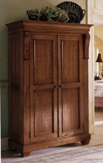 a wooden cabinet with a basket on top of it in a bedroom next to a bed