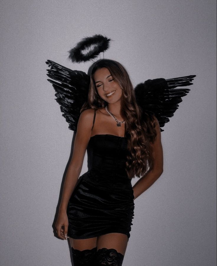 a woman in a black dress and angel wings