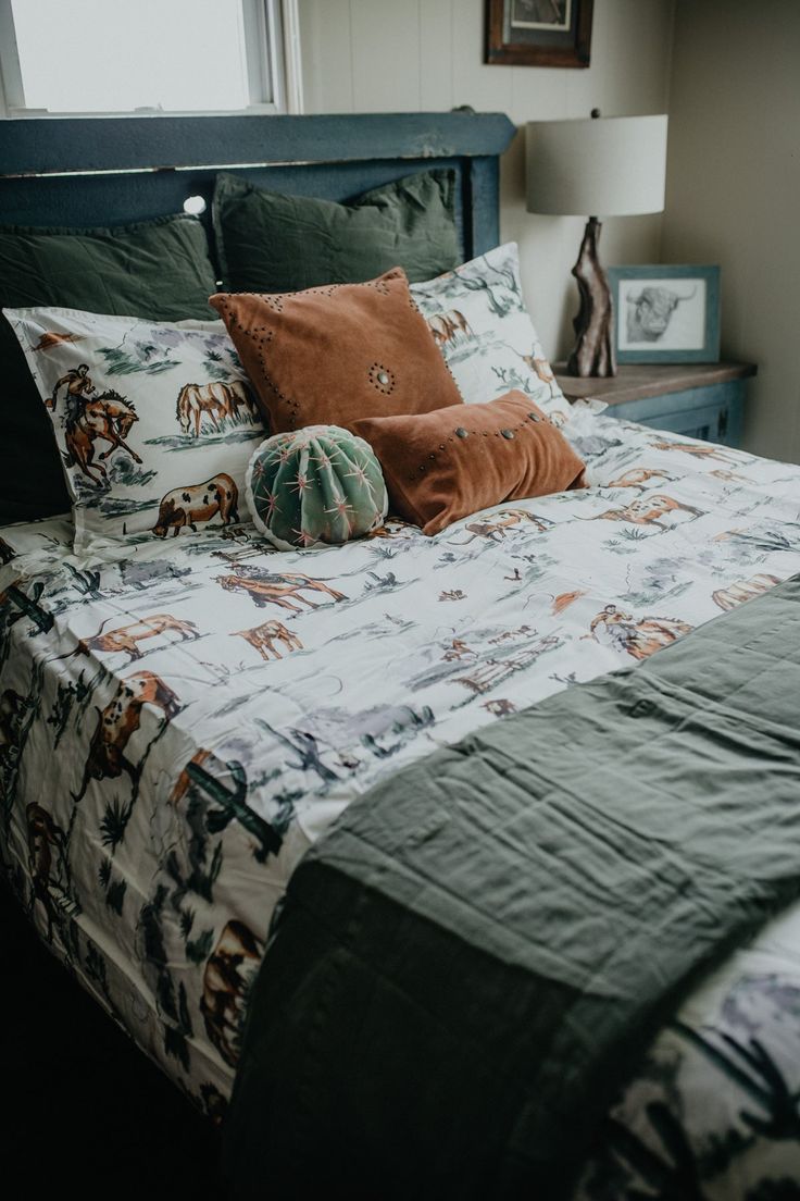 a bed with two pillows on top of it and an animal print comforter in the middle