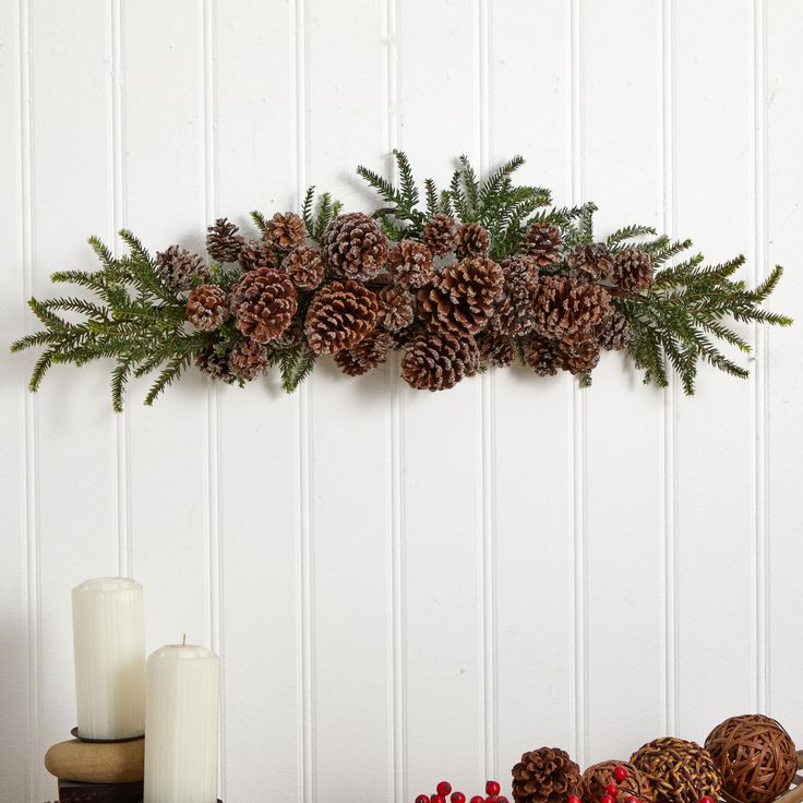 pine cones and greenery are hanging on the wall