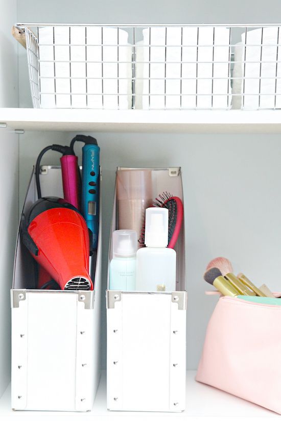 two white bins filled with personal items on top of a shelf next to a pink purse