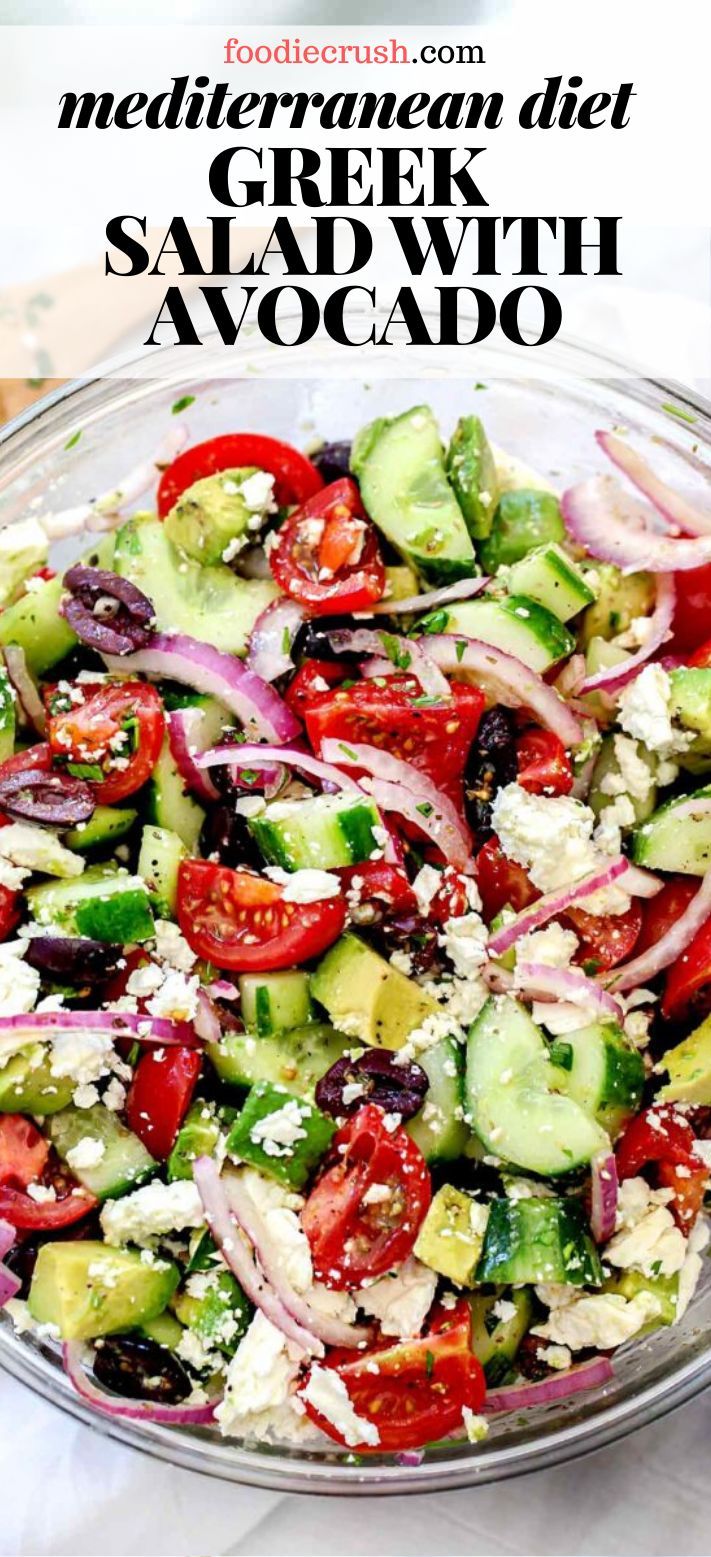 a salad with cucumbers, tomatoes, onions and feta cheese in a glass bowl