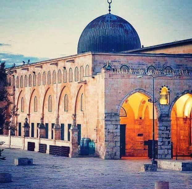 an old building with a dome on the top and lights at the entrance to it