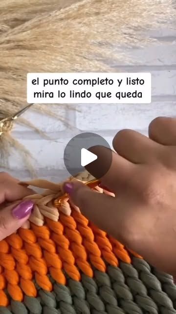 two hands crocheting an orange and grey knitted blanket with text that reads, el punto completo y listo