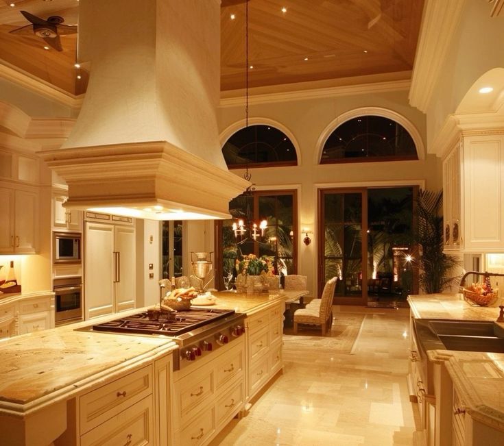 a large kitchen with white cabinets and an island in front of the stove top oven