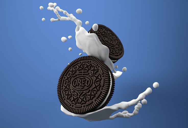 an oreo cookie falling into milk with splashing milk on the top and bottom