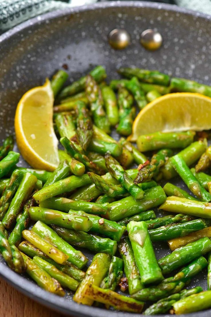 asparagus and lemon in a pan on a wooden table