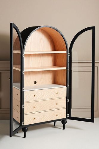 an arch shaped cabinet with drawers and shelves